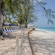 Beach chairs and a picket fence along a white sand beach